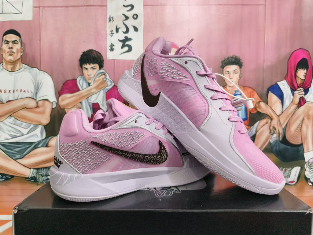 Angled view of the pink shoes showing textured side panels and white midsoles