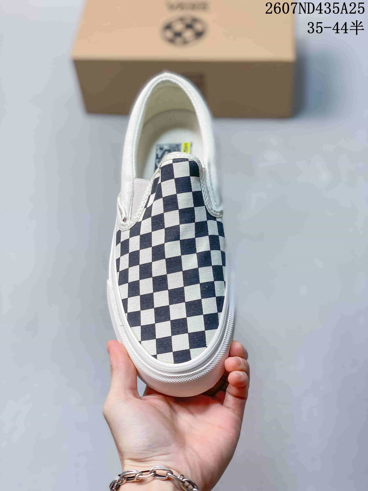 Top view of a single checkerboard slip-on sneaker with white trim.