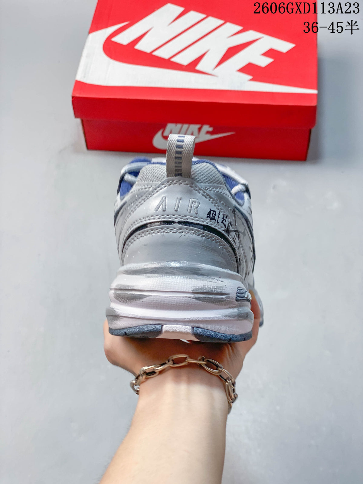 Rear view of the silver sneaker showing the heel panel and chunky midsole.