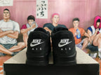Rear view of black Nike sneakers showing contrasting Nike and AIR heel lettering.