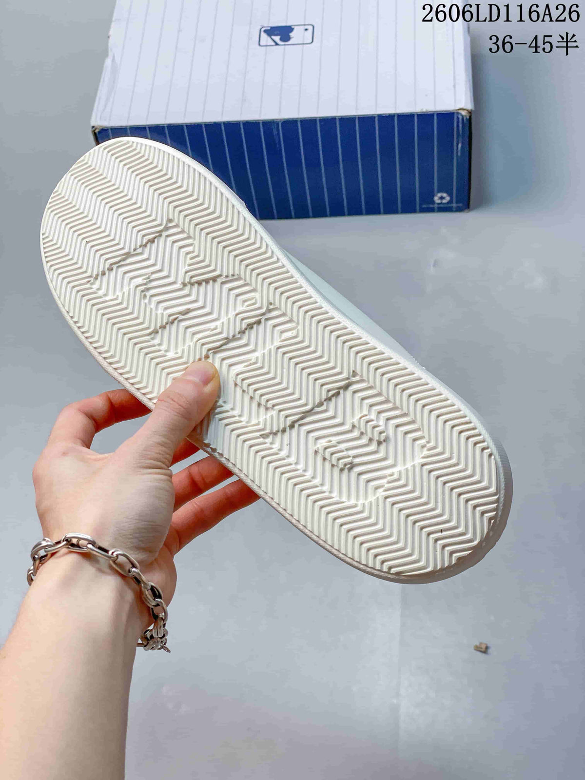 Close-up of the white sneaker outsole showing a repeating herringbone tread pattern.