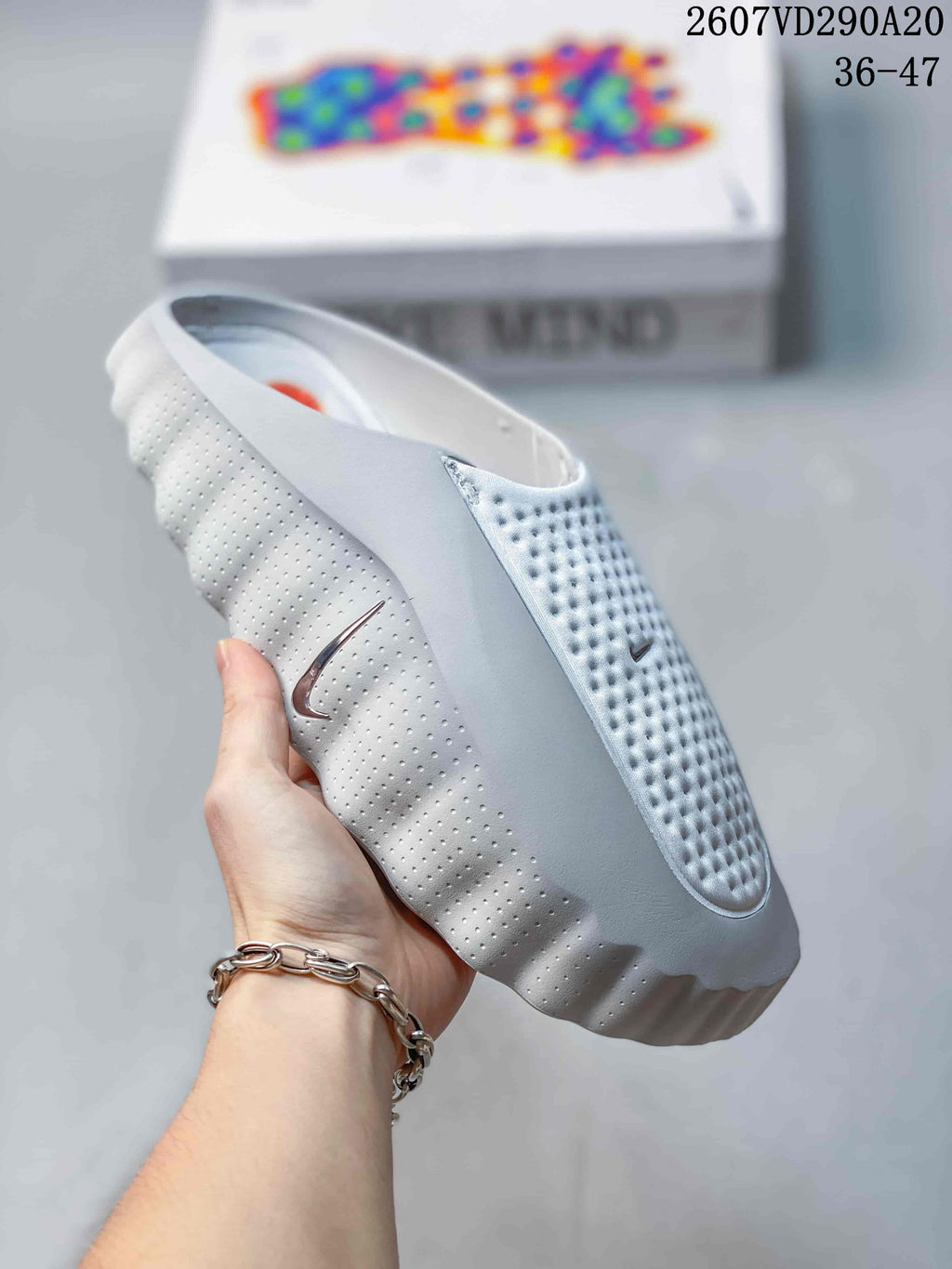 Angled side view of the white Nike slide sandal showing the perforated upper, side Swoosh, and sculpted sole.