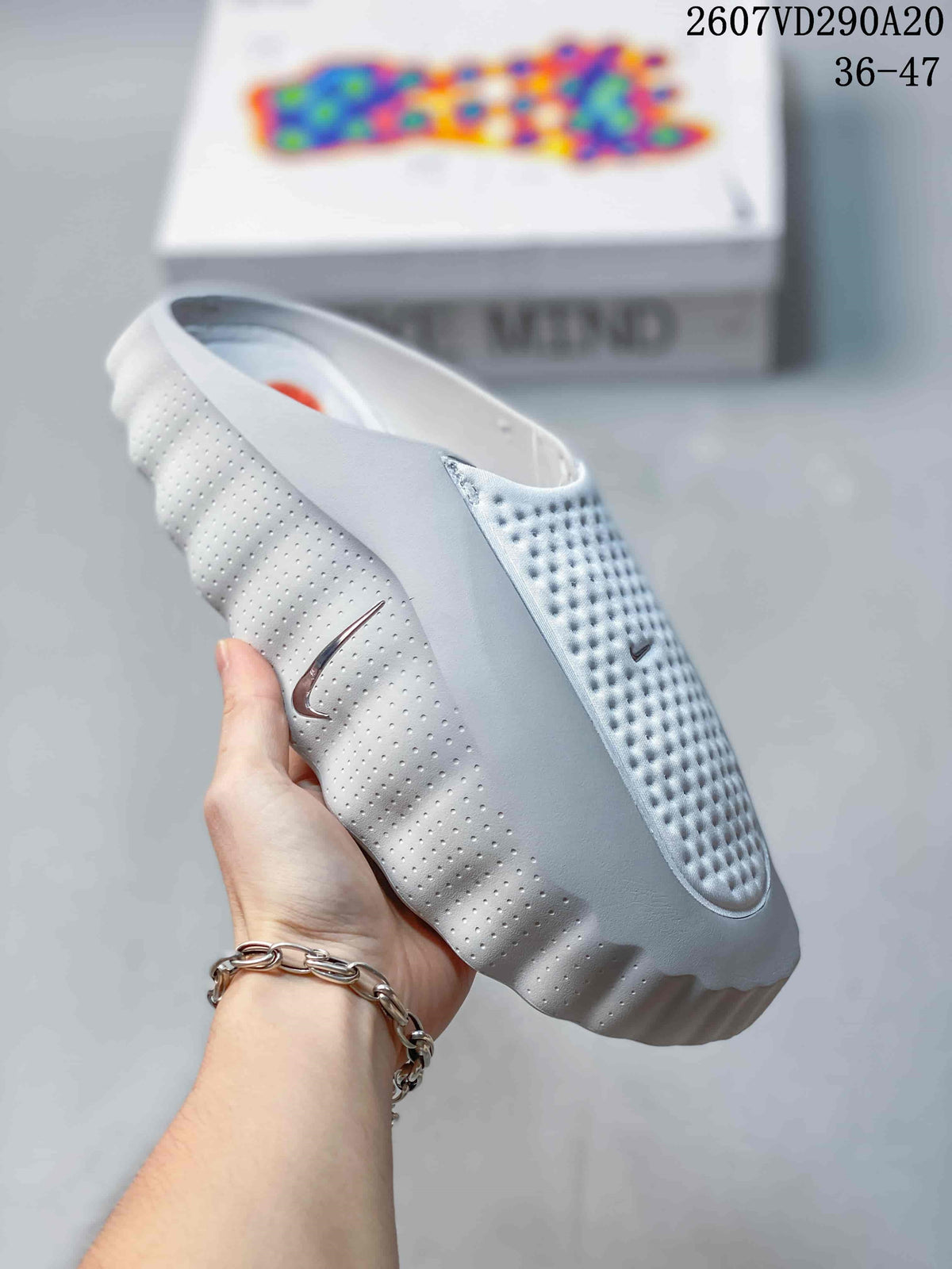 Angled side view of the white Nike slide sandal showing the perforated upper, side Swoosh, and sculpted sole.