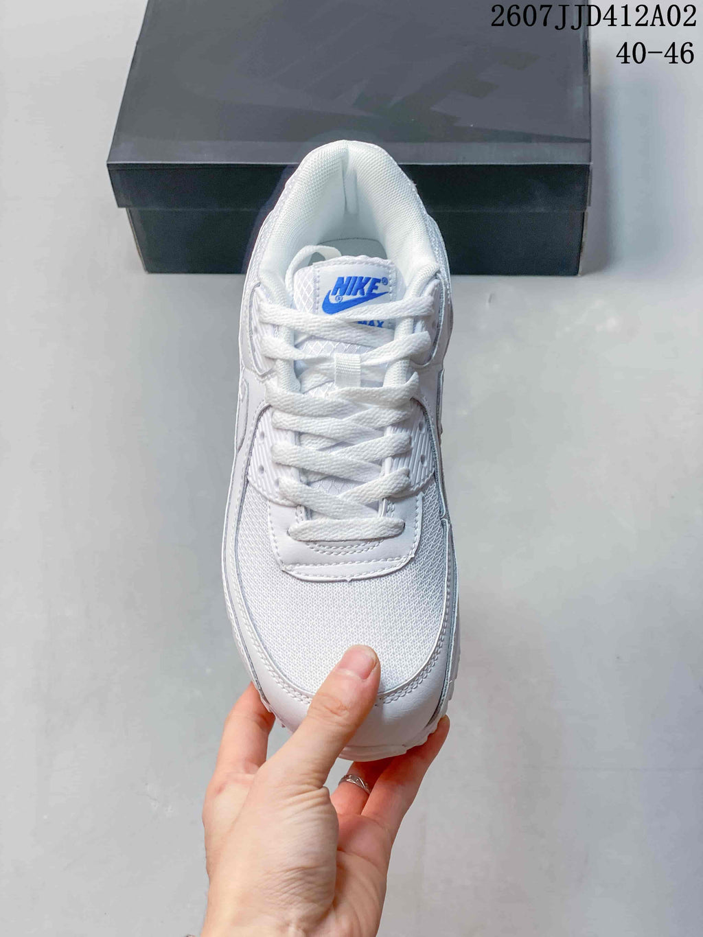 Top view of a white lace-up sneaker with a blue tongue logo