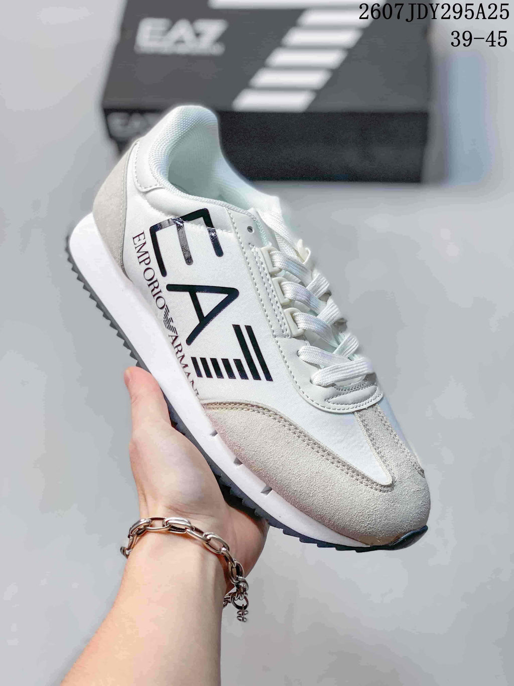 Close-up of a white Emporio Armani EA7 sneaker with black side branding, a light gray toe panel and a white midsole.