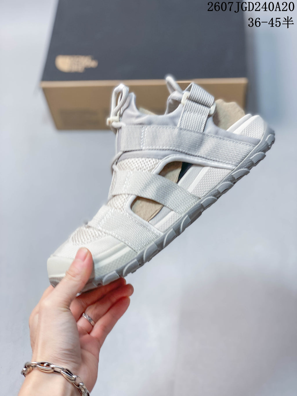 Side view of the sandal showing layered webbing straps, mesh panels, open sides, and the thick outsole.