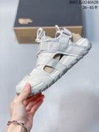Side view of the sandal showing layered webbing straps, mesh panels, open sides, and the thick outsole.