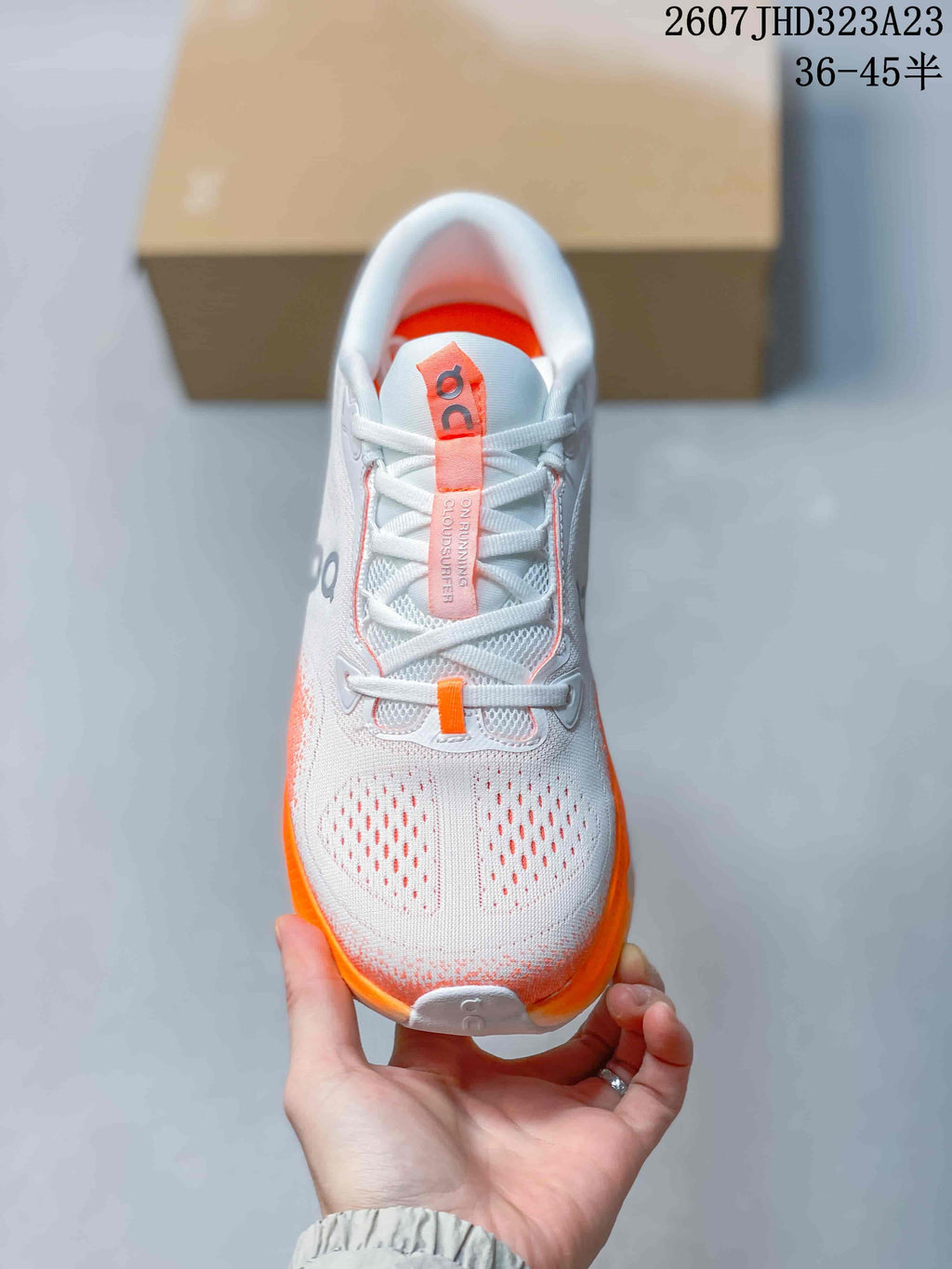 Top view showing the white laces, perforated toe area, padded tongue, and orange accents.