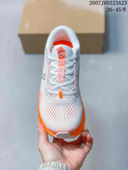Top view showing the white laces, perforated toe area, padded tongue, and orange accents.