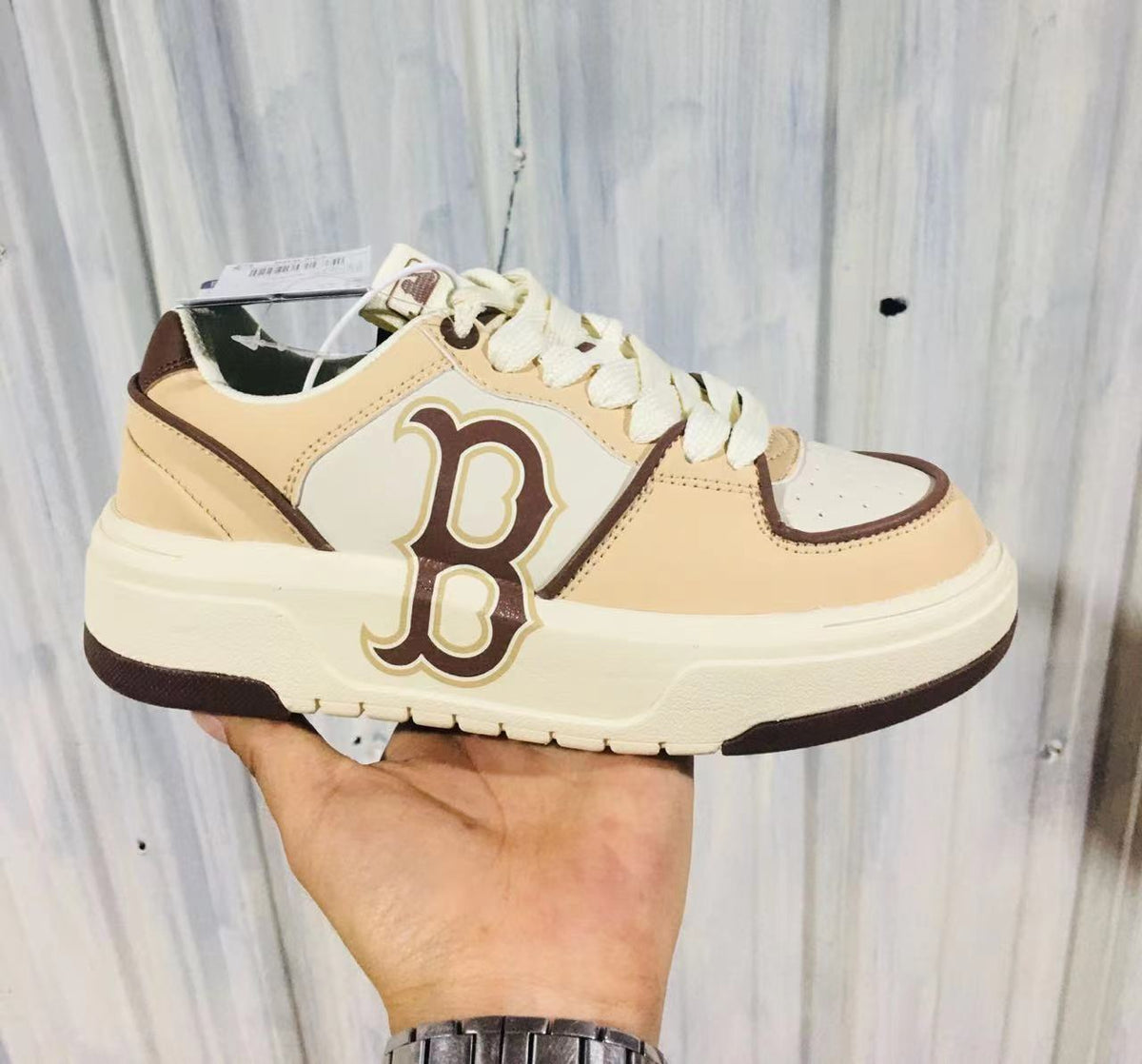 Light coffee and cream MLB sneaker with a large brown-and-cream side emblem, cream laces, contrast trim, and layered rubber sole.