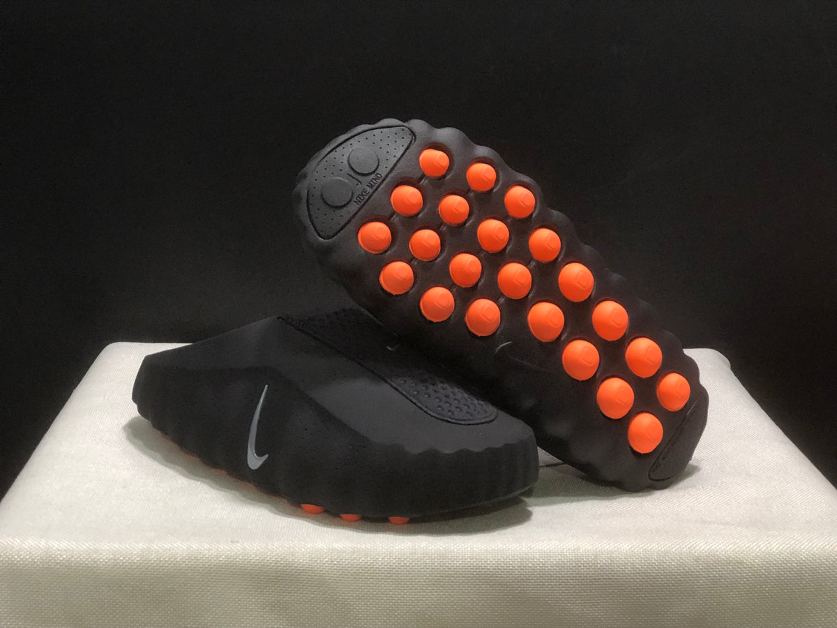 Angled underside view showing the black outsole and multiple raised orange pods.