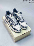 Pair of Nike Air Force 1 low-top sneakers with white and navy floral uppers displayed on a shoebox.