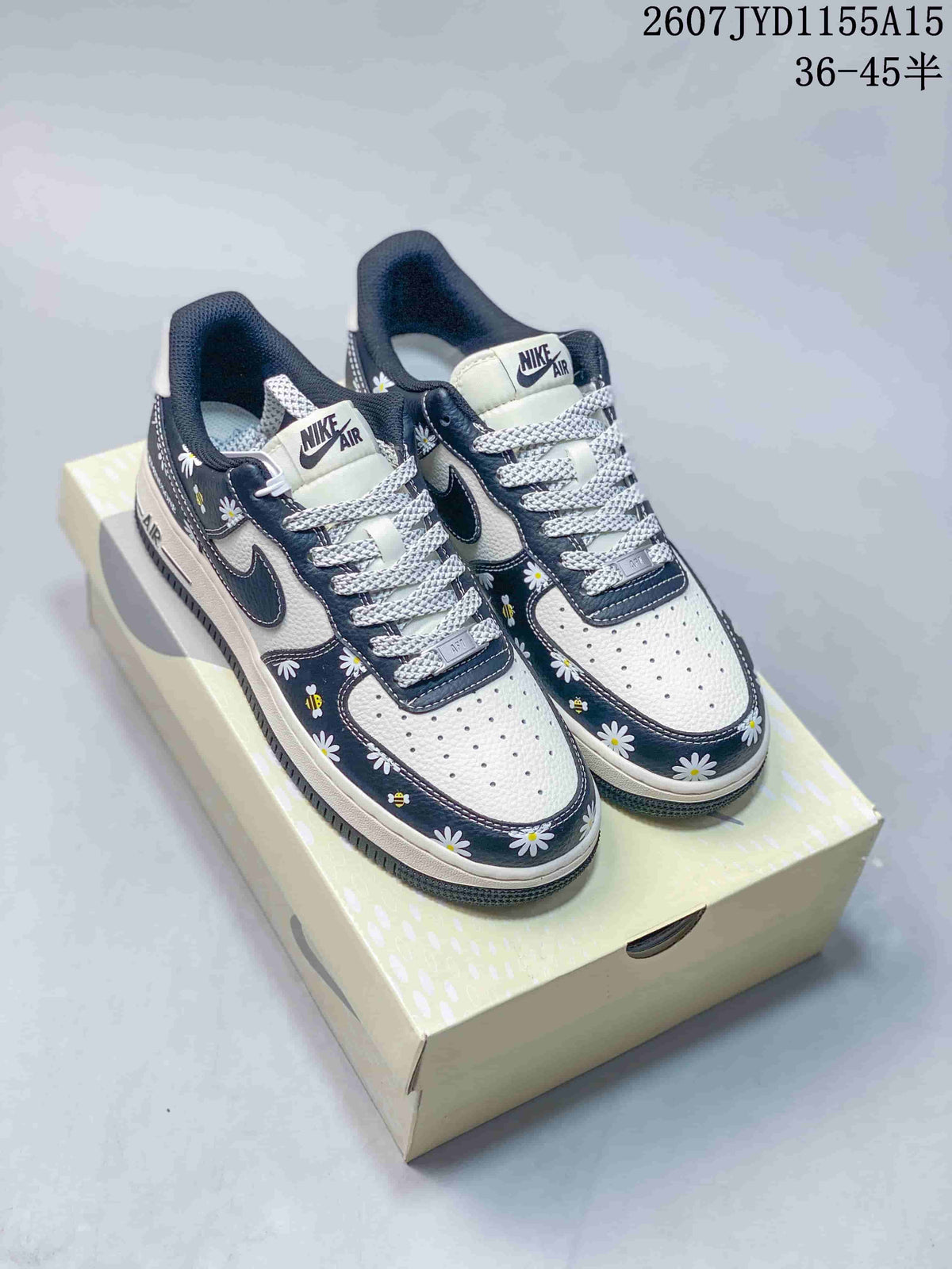 Pair of Nike Air Force 1 low-top sneakers with white and navy floral uppers displayed on a shoebox.
