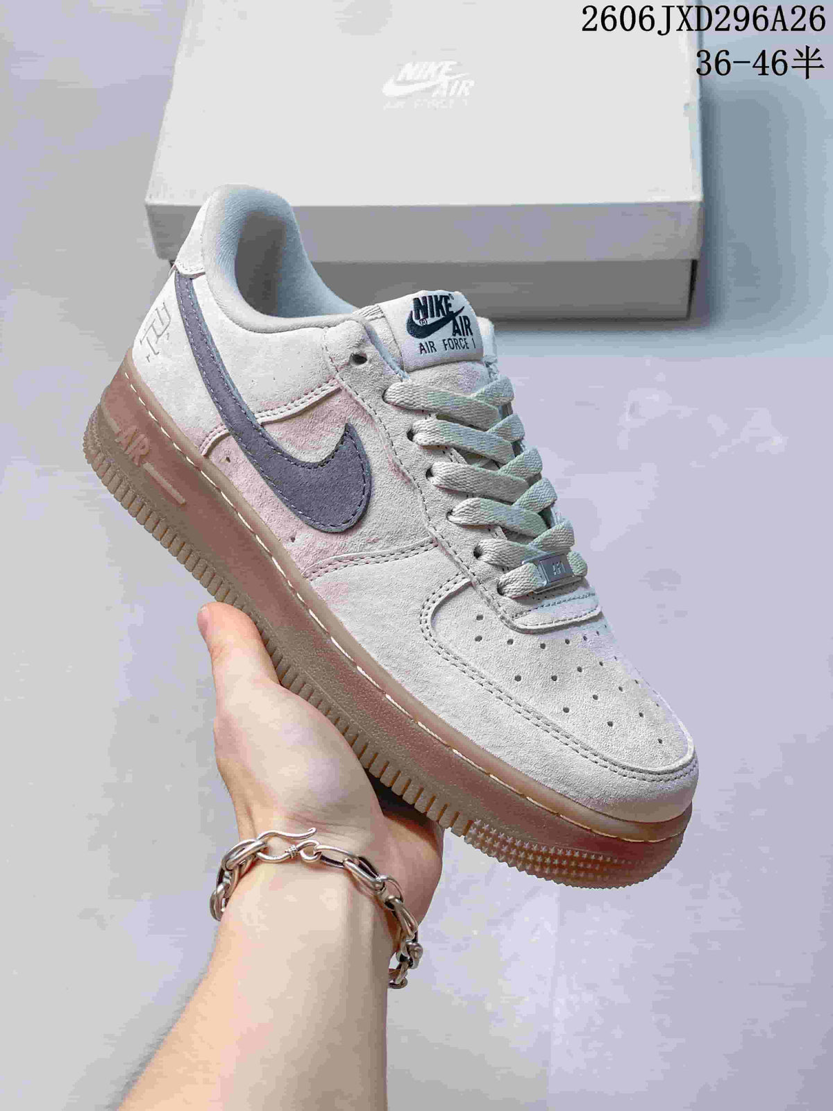 Pale gray Nike Air Force 1 low-top sneaker with a dark Swoosh and gum-tone sole.