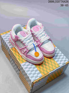 Pair of pink and white Louis Vuitton Trainer-style low-top sneakers displayed on a patterned box