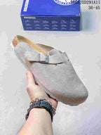 Light gray suede-like closed-toe sandal with an adjustable buckle, shown beside a Birkenstock-branded box.