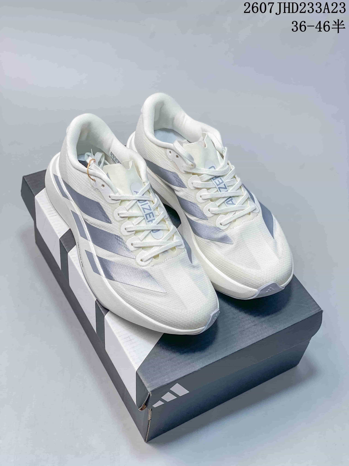 Pair of white Adidas Adizero Evo SL sneakers with light blue-gray side details displayed on an Adidas shoebox.