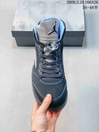 Front view of a dark high-top sneaker with light blue collar lining and lace toggle.