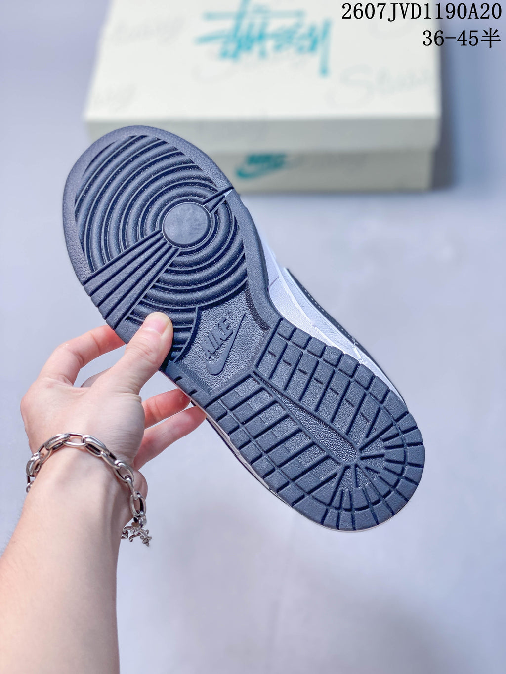 Close view of the black patterned outsole showing circular forefoot traction and a Nike mark.