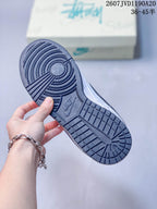 Close view of the black patterned outsole showing circular forefoot traction and a Nike mark.