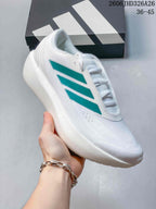 Angled side view of the white shoe with teal stripes and thick sole