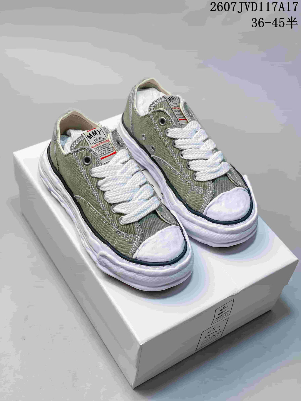 Pair of olive MMY low-top canvas sneakers with white laces, white toe caps and sculpted white soles.