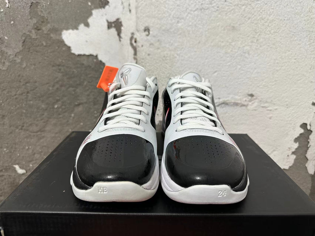 Front view of white and black Nike Kobe basketball shoes with perforated toe panels and white laces.