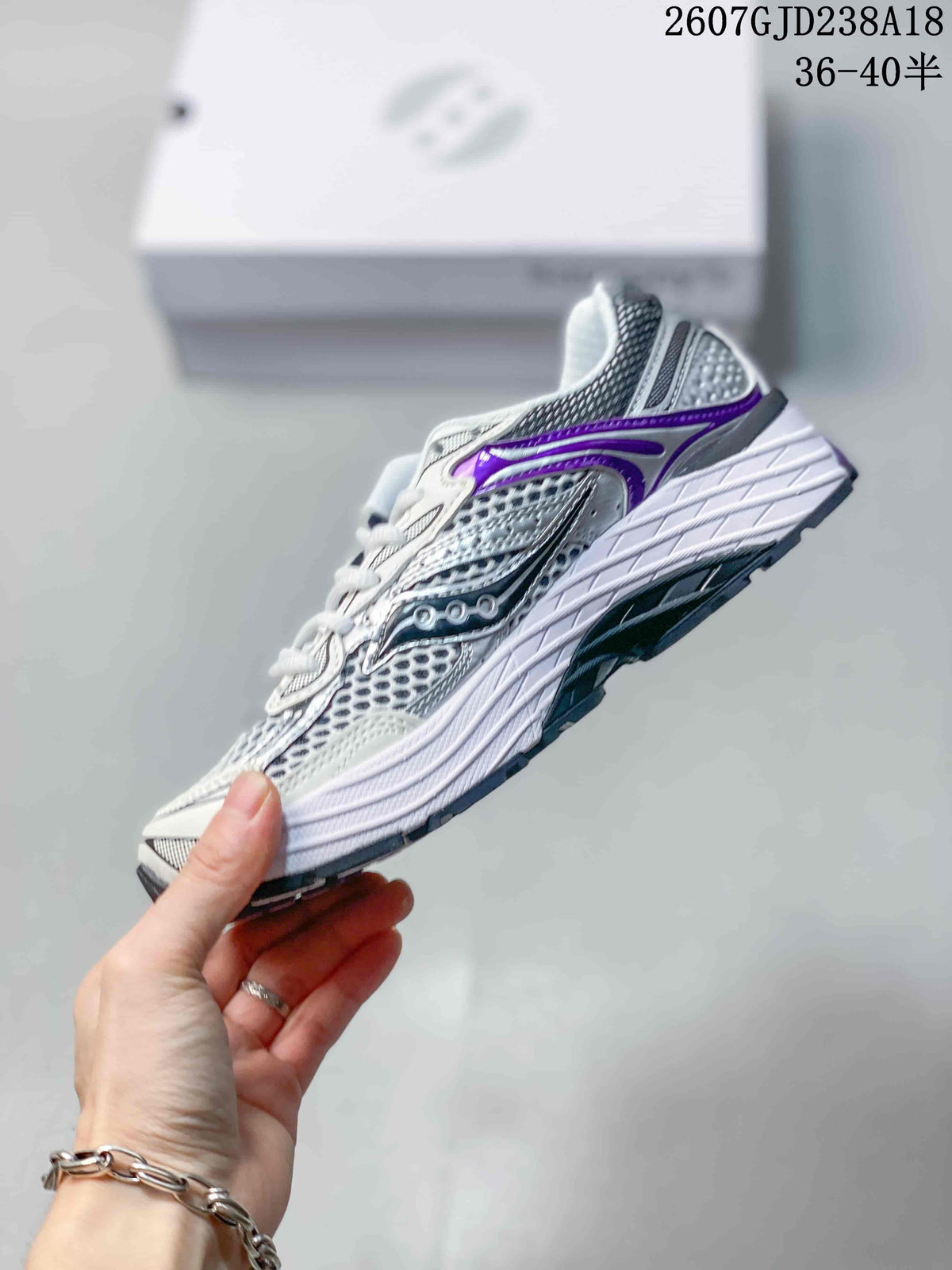 Side profile of a white, gray and purple Saucony Progrid Omni 9 sneaker with layered panels and a contrasting outsole.