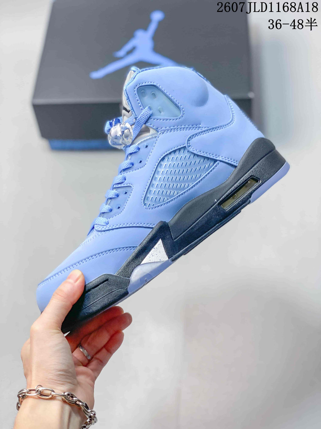 Side profile showing the light blue layered upper, side mesh panel, lace-up construction, dark midsole and visible cushioning window.