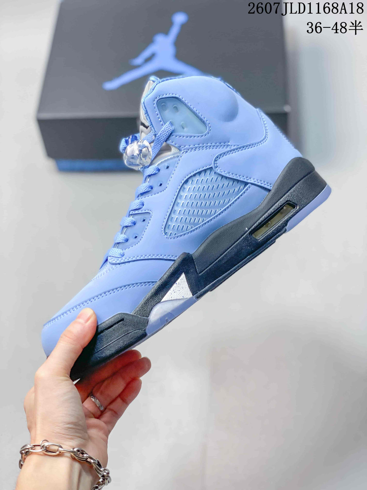 Side profile showing the light blue layered upper, side mesh panel, lace-up construction, dark midsole and visible cushioning window.