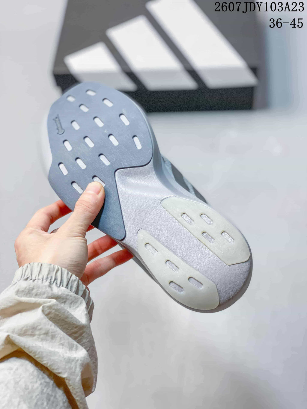 Close-up of the outsole showing gray and white sections with elongated traction openings.