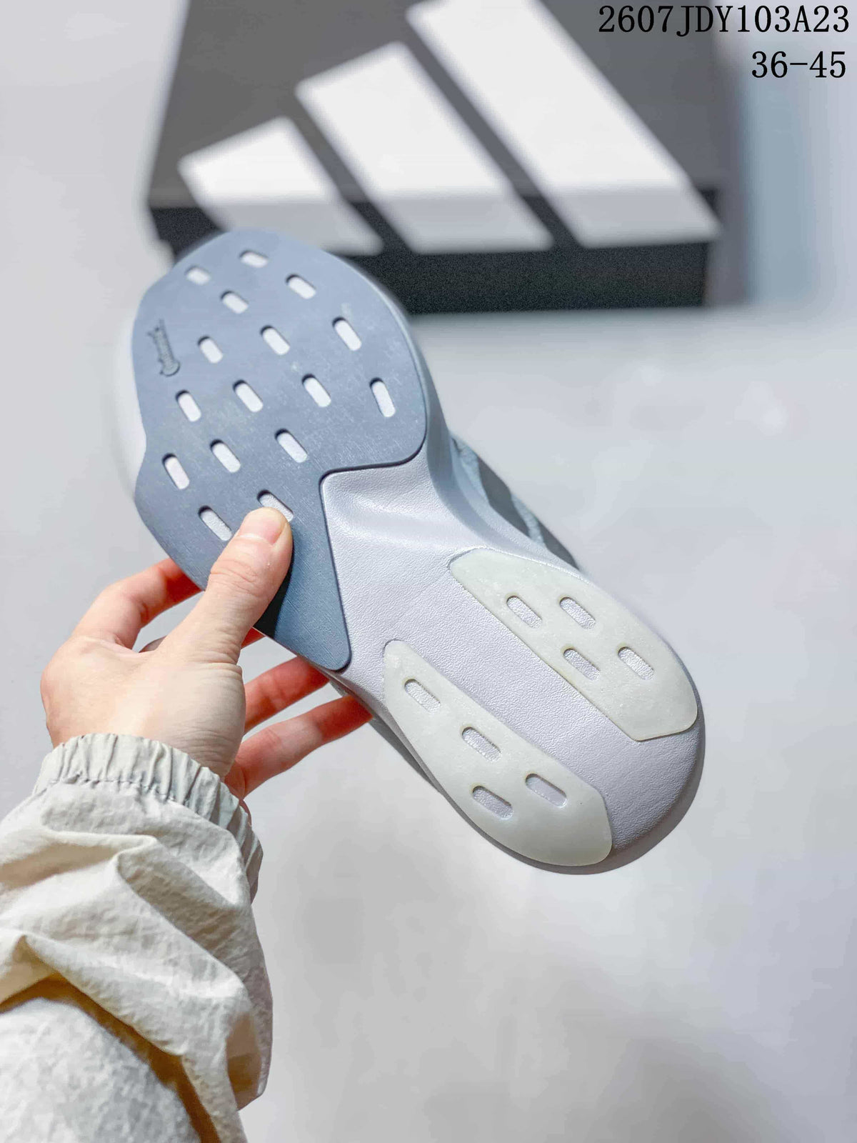 Close-up of the outsole showing gray and white sections with elongated traction openings.
