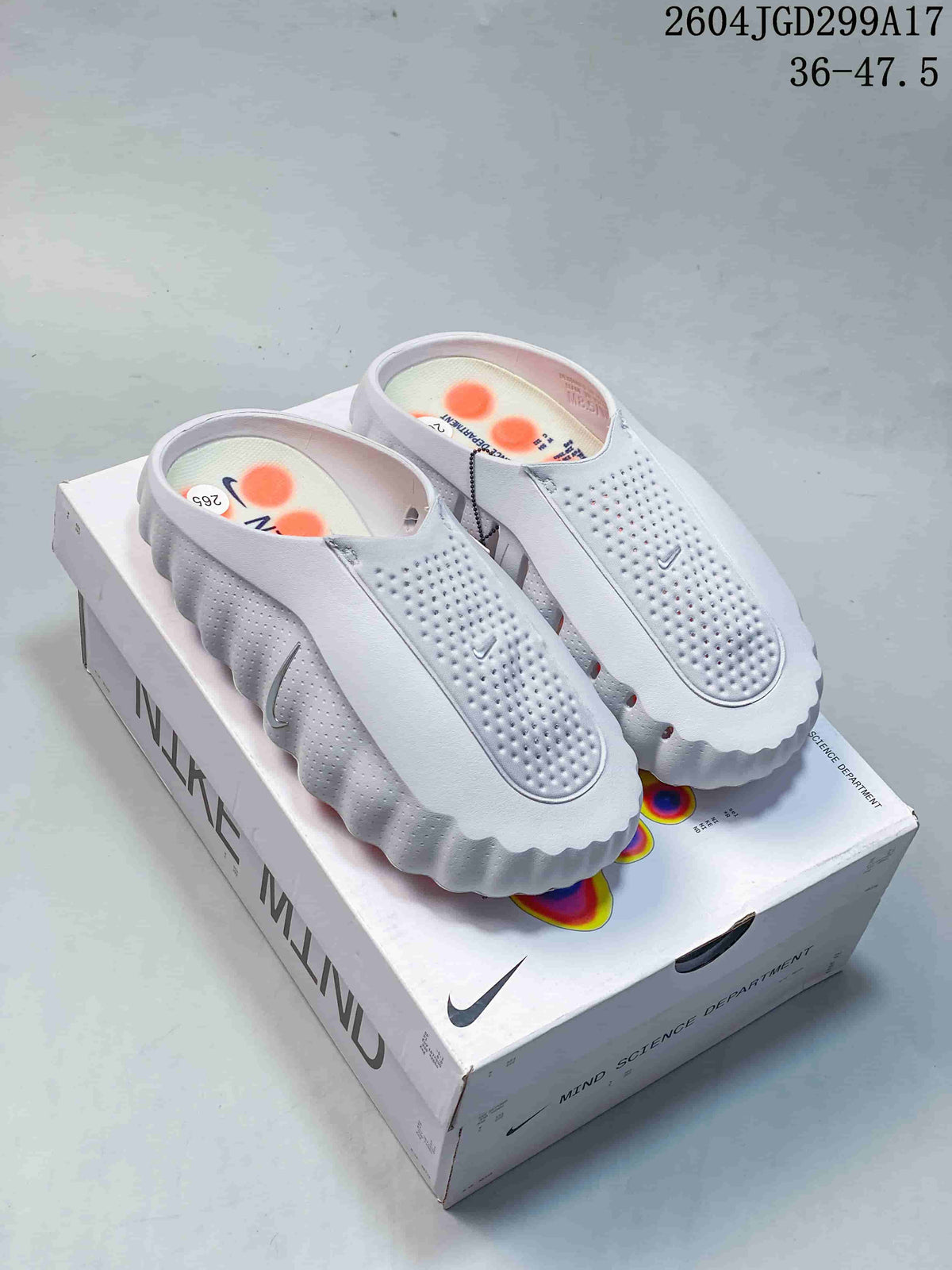 White Nike Mind slide pair displayed on a Nike Mind box.