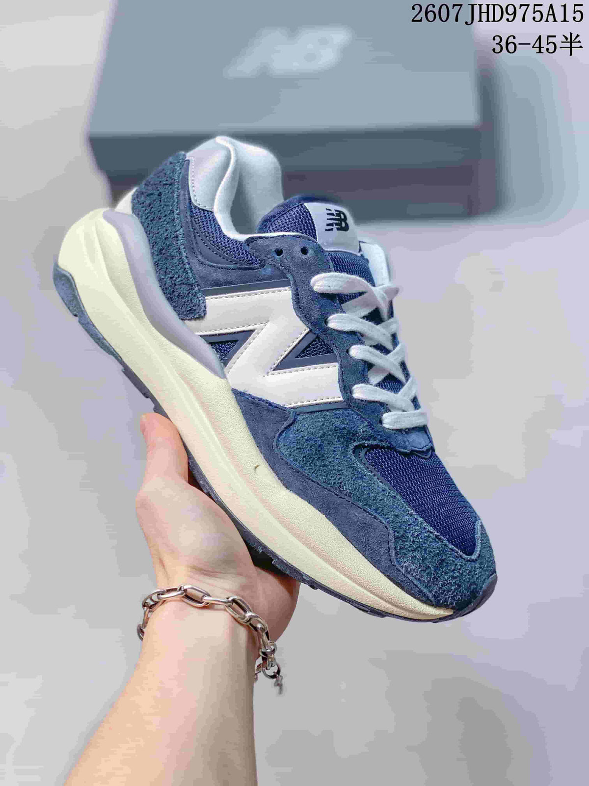Angled side view of a navy and white New Balance 5740 sneaker with a textured upper and contrasting midsole.