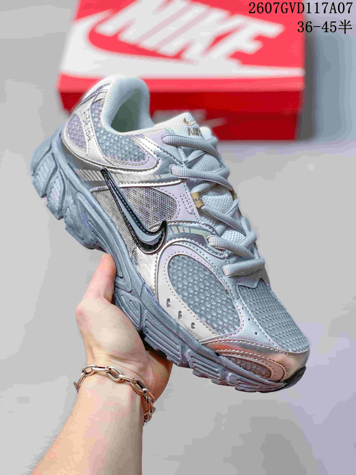Angled side view of the silver and gray low-top sneaker with layered panels and textured outsole.