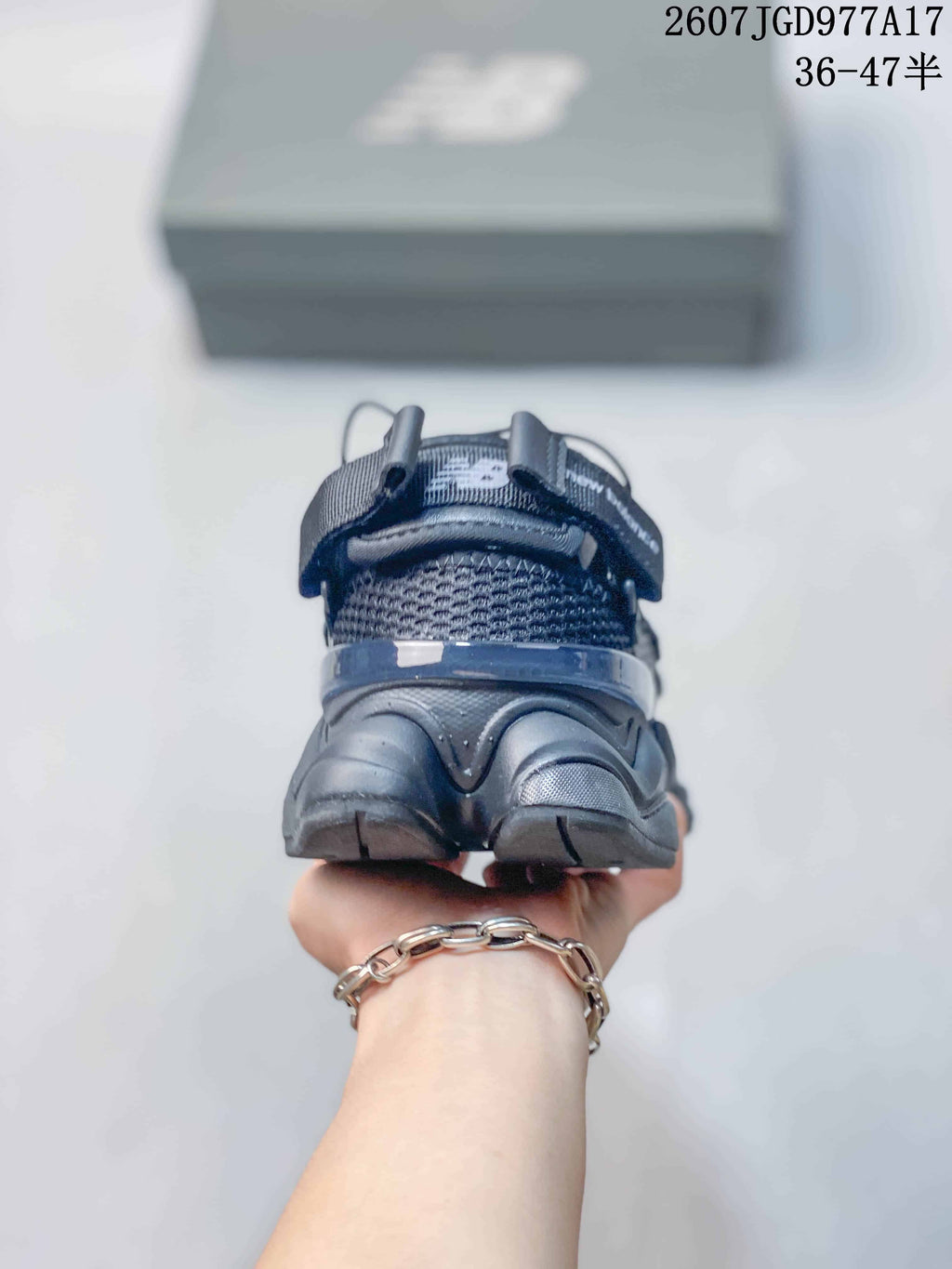 Rear view of the dark New Balance 9060 sneaker showing the open-heel mule construction, padded collar, and heel structure.
