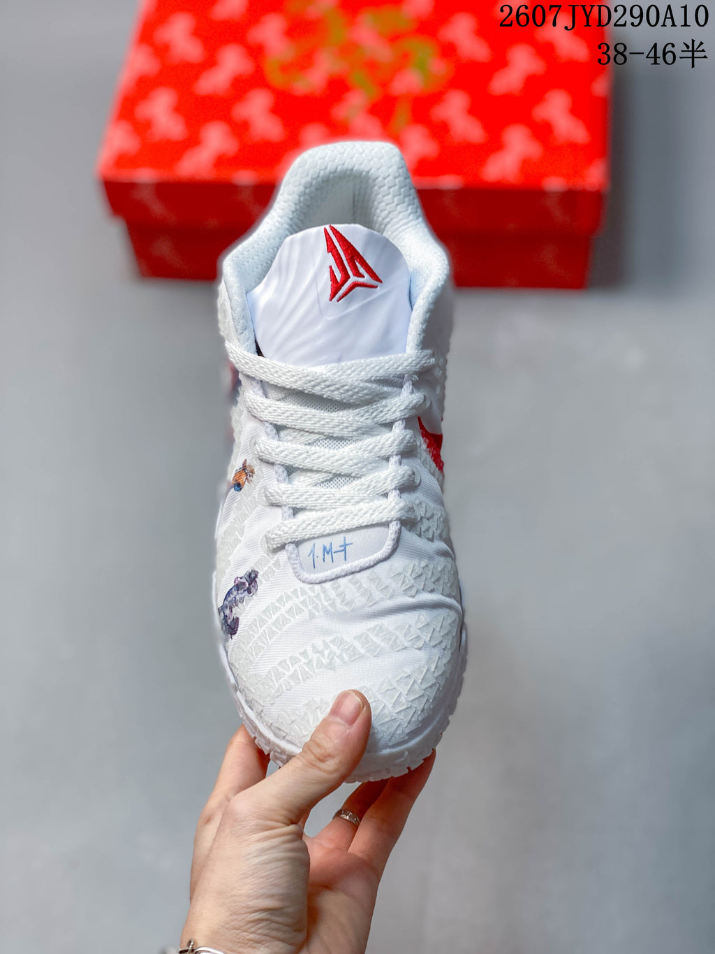 Front view showing white laces, Ja tongue branding and illustrated upper details.