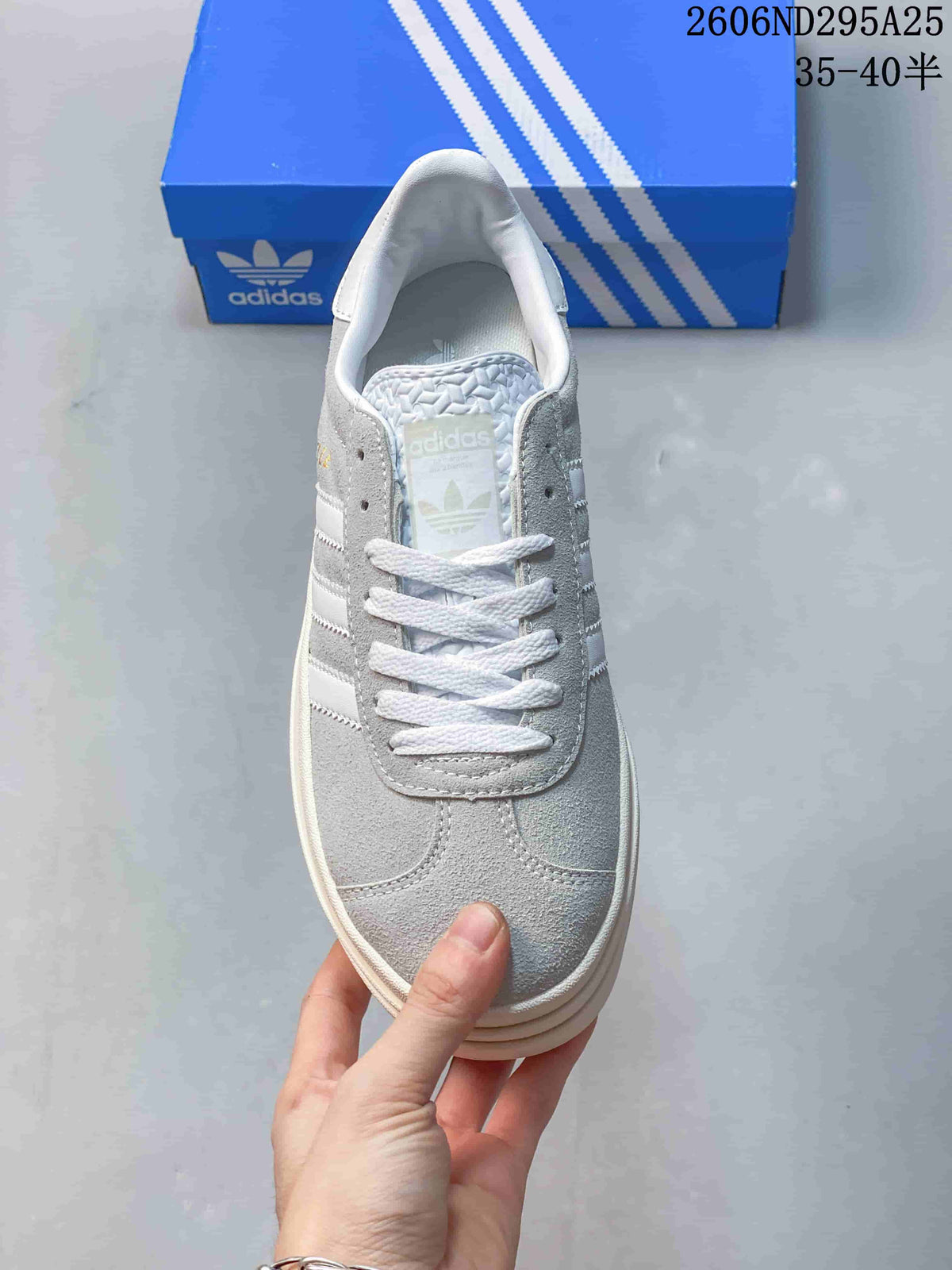 Top view showing the rounded toe, white laces, grey panels, and trefoil tongue branding.