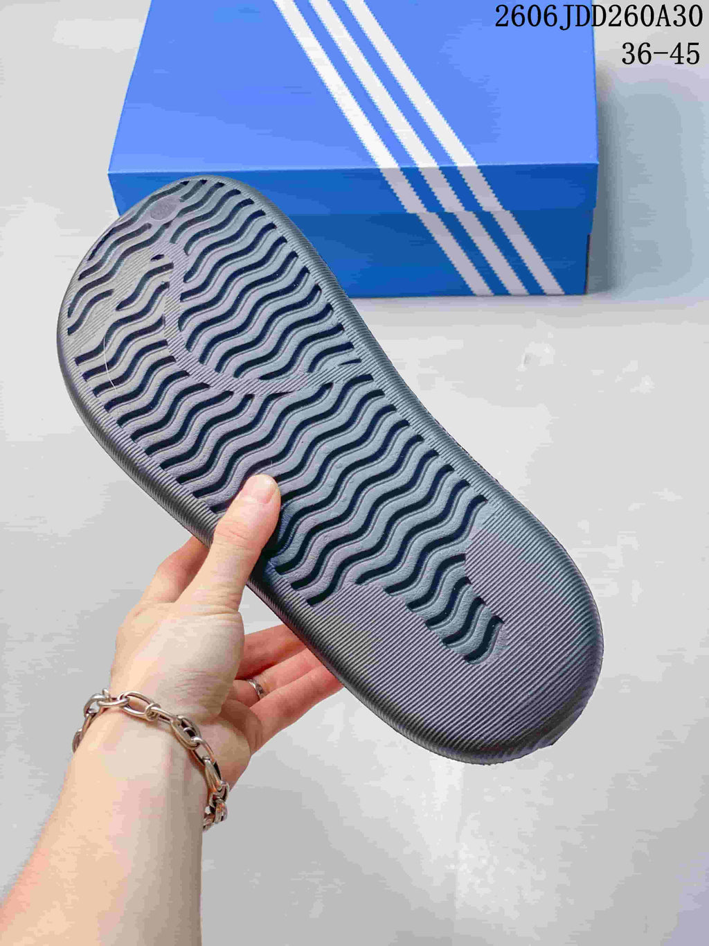 Close-up of the patterned outsole of a charcoal mule slide