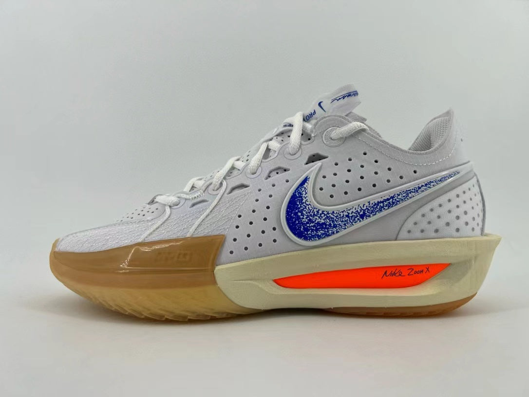 Side view of a light gray and white Nike running shoe with a blue patterned Swoosh, orange midsole accent, and gum-colored outsole.