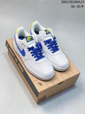 Pair of white Nike Court Vision Low sneakers with blue laces and yellow accents displayed on a shoebox.