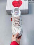 Top view of the sneaker showing perforations on the toe box, pale pink laces, and a branded tongue label.