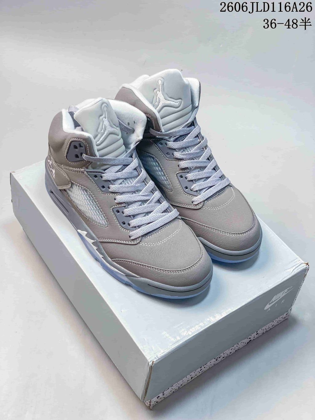 Pair of grey Jordan Air Jordan 5 Retro high-top sneakers on a shoe box