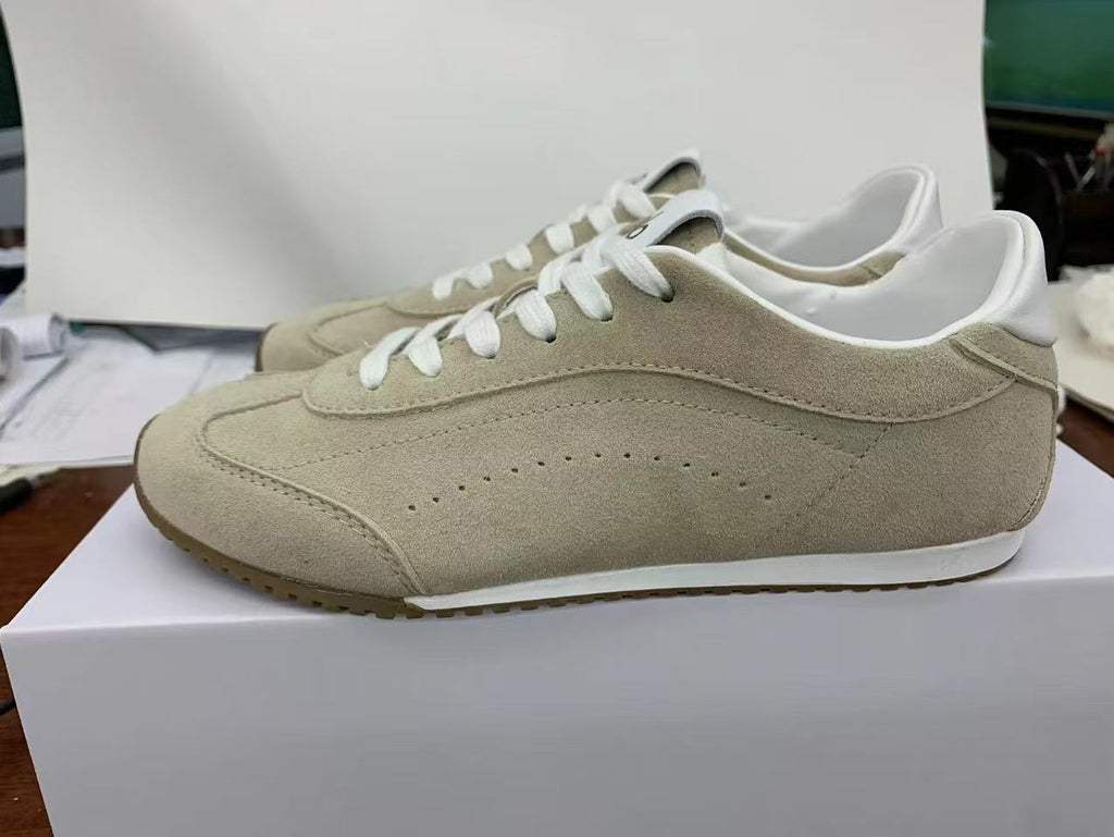 Side view of beige low-top Alo sneakers with white laces, white midsole and brown outsole.