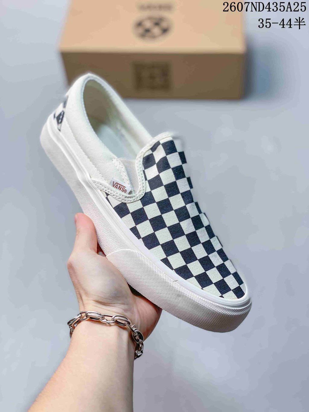 Close-up of a navy-and-white checkerboard slip-on sneaker with white sidewalls and visible Vans branding.