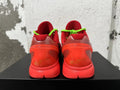 Rear view of red Nike Kobe basketball sneakers with neon green laces and signature-style heel details