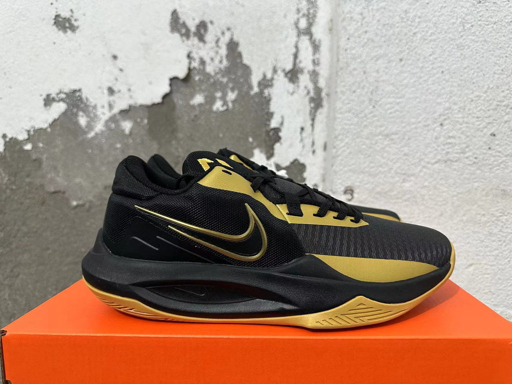Side view of a black and gold Nike basketball sneaker with a Swoosh logo