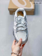 Top view of a silver and white ASICS Hypersync sneaker showing the lace-up front, padded tongue, textured forefoot, and rounded toe.