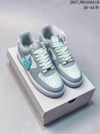 Pair of pale blue and white Nike Air Force 1 '07 style low-top sneakers displayed on a shoebox.