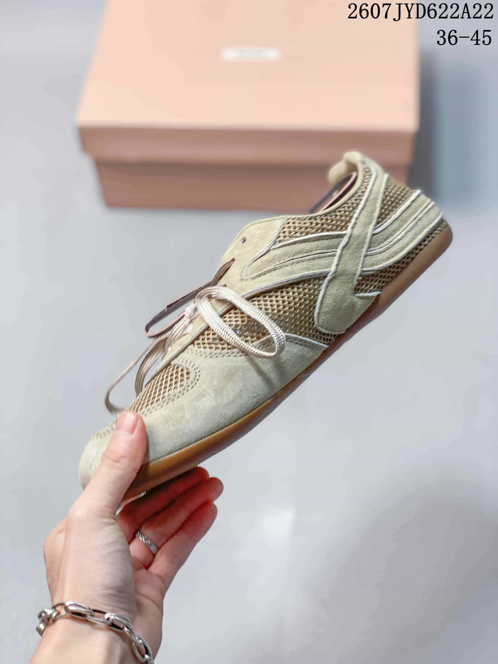 Side profile of the light beige low-top sneaker showing layered panels, mesh sections, lace fastening, and a gum-tone outsole; image text shows 2607TYD622A22 and 36–45.